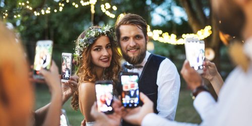 guests-with-smartphones-taking-photo-of-bride-and-groom-at-wedding-reception-outside-scaled-1.jpg guests-with-smartphones-taking-photo-of-bride-and-groom-at-wedding-reception-outside-scaled-1.jpg